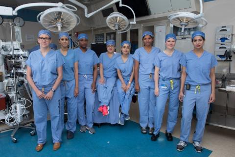 Eight women standing in scrubs in an operating room